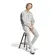Ανδρικό παντελόνι φόρμας Adidas Essentials Big Logo French Terry γκρι, συνδυασμένο με γκρι φούτερ και λευκά sneakers, καθιστή πόζα.